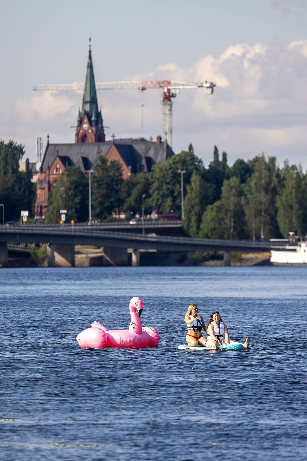 Flamingoflotte driver genom Umeå med stadskyrkan i bakgrunden