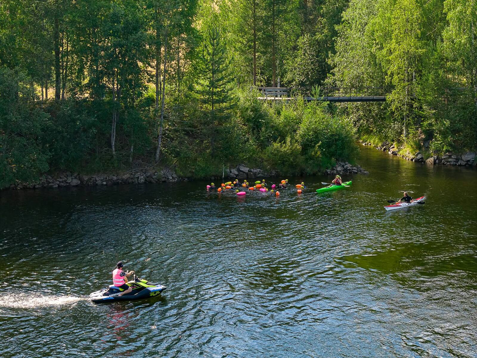 Safety on the water — a jet ski and kayak follow the floaters.
